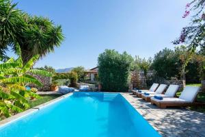 a swimming pool with chaise lounge chairs and a swimming pool at A 3bedroom country house, with pool close to beach in Roumelí