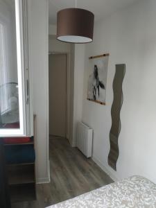 オルレアンにあるT2 de charme - Bords de Loire ORLEANSのベッドルーム1室(ベッド1台付)、壁にランプが備わります。