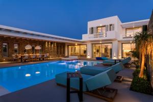 a villa with a swimming pool at night at Splendid Mykonos Luxury Villas & Suites in Mikonos