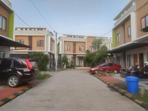 een parkeerplaats met auto's voor gebouwen bij Colombus Residence Karawang Mitra RedDoorz in Telukjambe