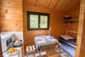 a small room with a table in a log cabin at Camping de Collonges-la-Rouge in Meyssac