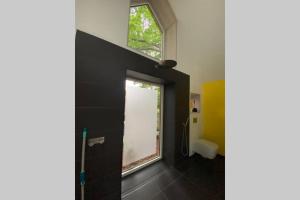a bathroom with a window and a shower in it at Oak Cottage near Rønne & Beach in Rønne