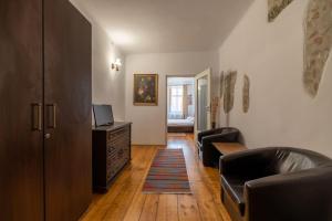 a living room with two leather chairs and a television at Conrad Haas Apartment in Sibiu