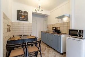 a kitchen with a table and chairs and a microwave at Conrad Haas Apartment in Sibiu