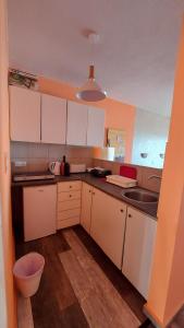 una cocina con armarios blancos y fregadero en Pomelo Apartments, en Ayia Napa
