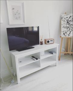 um centro de entretenimento branco com uma televisão de ecrã plano em DA-DA Gallery Appart - modern and luxury studio in Boudry em Boudry