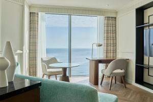 a living room with a couch and a table and a window at Grand Josun Busan in Busan