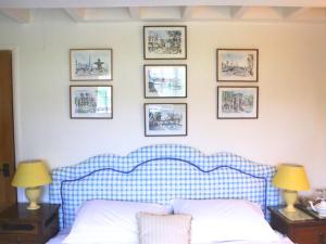 a bedroom with a blue and white bed and pictures on the wall at Stone House in Sulgrave