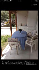 une table et deux chaises avec une table et des chaises bleues dans l'établissement Kuşadası Tatil Evi, à Soğucak