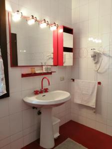 bagno con lavandino, specchio e servizi igienici di B&B Casa Silingardi a Bagnolo San Vito