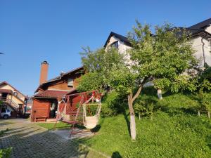 a tree with a swing in front of a house at Casa Daya in Topliţa