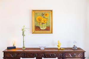 a painting of flowers in a vase on a table at Espinho Sunshine Flat in Espinho +26 photos
