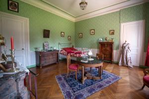 a bedroom with a bed and a table in a room at CHATEAU D HUGLEVILLE in Hugleville-en-Caux