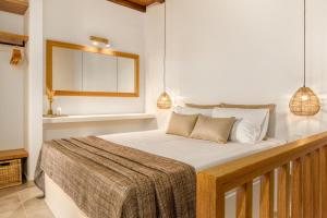 a bedroom with a bed and a window and pendant lights at Shizen Houses in Serifos Chora