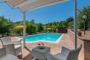 a swimming pool with chairs and an umbrella at Villa Design in Pergola