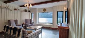 ein Wohnzimmer mit 2 Stühlen und einem großen Fenster in der Unterkunft Black Sheep Hotels Cabins in Spean Bridge