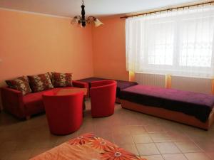 Krásnohorské PodhradieにあるUbytovanie Bettyの赤と紫の家具と窓が備わるリビングルーム