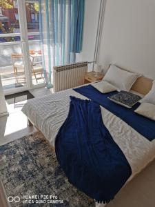 a bedroom with a bed with a blue blanket on it at City Lake Pearl #lake Jarun#green area#free parking#cafes, tram to city, markets#balcony&sunny in Zagreb