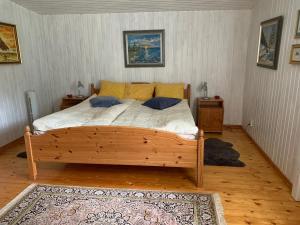 um quarto com uma cama de madeira e 2 almofadas em Almagården lantlig miljö em Svängsta