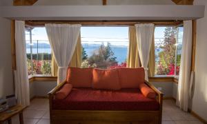 sala de estar con sofá frente a una ventana en Lagos del Sur en San Carlos de Bariloche