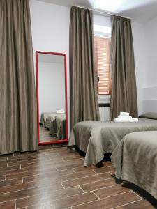 a mirror in a room with two beds at Hotel Calaluna in Biella