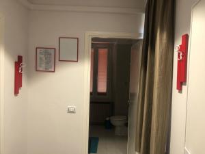 a bathroom with a toilet and a door to a room at Hotel Calaluna in Biella