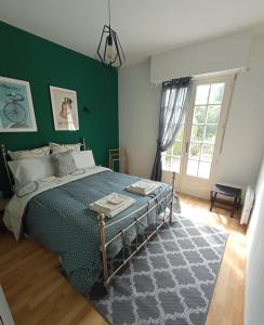 a bedroom with a bed with a green wall at By The Lake in La Trinité-Porhoët