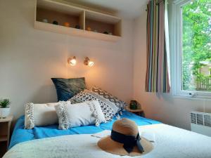 a bedroom with a blue bed with a hat on it at Camping du Lac de Saint-Pardoux in Saint-Pardoux