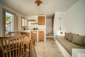 a kitchen and living room with a table and a couch at Shizen Houses in Serifos Chora