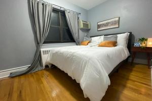 a bedroom with a bed with white sheets and a window at Reduced Priced! Apt by American Dream, Sleeps 6 in Lodi +19 photos
