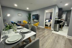 uma sala de jantar e sala de estar com mesa e cadeiras em Luxury Meets Convenience! Near NYC & EWR Airport em Lodi