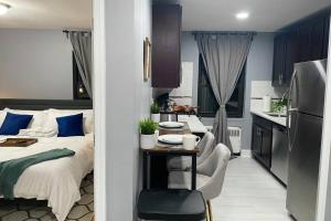 a bedroom with a bed and a table and a kitchen at Luxury Meets Convenience! Near NYC & EWR Airport in Lodi