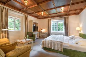 a bedroom with a bed and a couch and a table at Hotel Geldernhaus in Oberstdorf