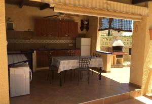 eine Küche mit einem Tisch und Stühlen sowie eine Küche mit einem Herd in der Unterkunft Casa Don Fernando in Moraira