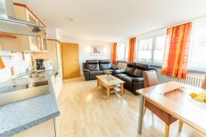 a kitchen and living room with a couch and a table at Hotel Alpenhof in Bad Wörishofen