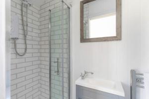 een badkamer met een douche, een wastafel en een spiegel bij Jabba, The Hut in Winchester