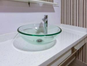 lavabo en el baño con una encimera de cristal en RyS Ourense Centro Amplia vivienda con Parking en Ourense