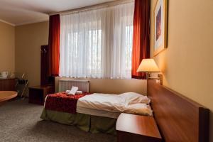 a hotel room with a bed and a window at Villa Plaza in Warsaw