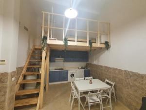 Zimmer mit einem Tisch und einer Küche mit einem Loft. in der Unterkunft Triana 143 - WIFI in Sevilla