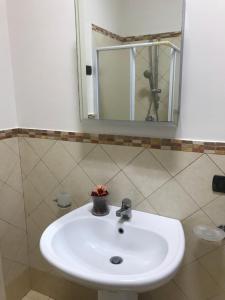un lavandino bianco in un bagno con uno specchio di GARIBALDI HOUSE a Marsala