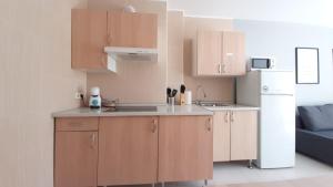 a kitchen with wooden cabinets and a white refrigerator at Toros Apartamentos in Palma de Mallorca