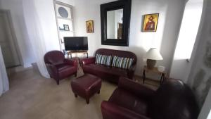 a living room with a couch and chairs and a mirror at Stone House Petra in Perast