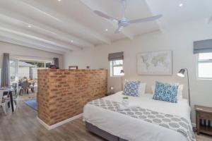 a bedroom with a bed and a brick wall at Ebb in Knysna