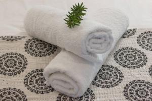 a white towel with a green plant on it at Ebb in Knysna