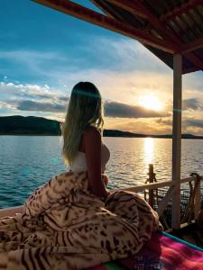 una mujer sentada en un barco mirando hacia el agua en Titicaca Uros Summa Paqari en Uros