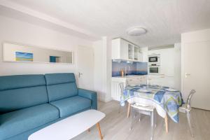 - un salon avec un canapé bleu et une table dans l'établissement Bel appartement pour un sejour au coeur de La Baule, à Pornichet