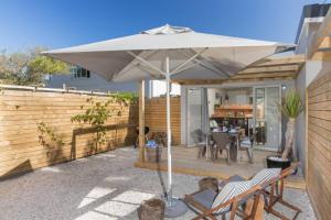 a patio with an umbrella and chairs and a table at Flow in Knysna