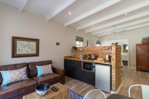 a living room with a couch and a kitchen at Flow in Knysna