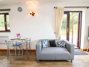 a living room with a couch and a table at Buckland Farm Studio in Watchet