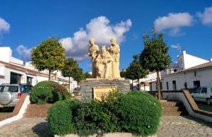 a statue of a group of people in a park at La Morada de Higuera in Higuera de la Sierra